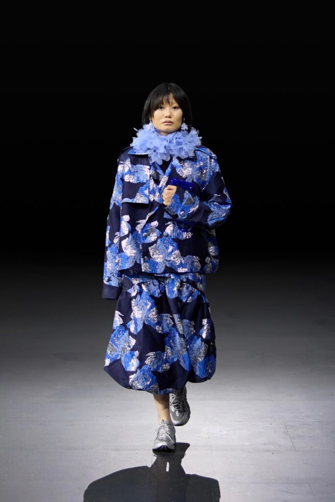 An oversized blue jacket with a printed design paired with a matching skirt, creating a bold fashion statement.