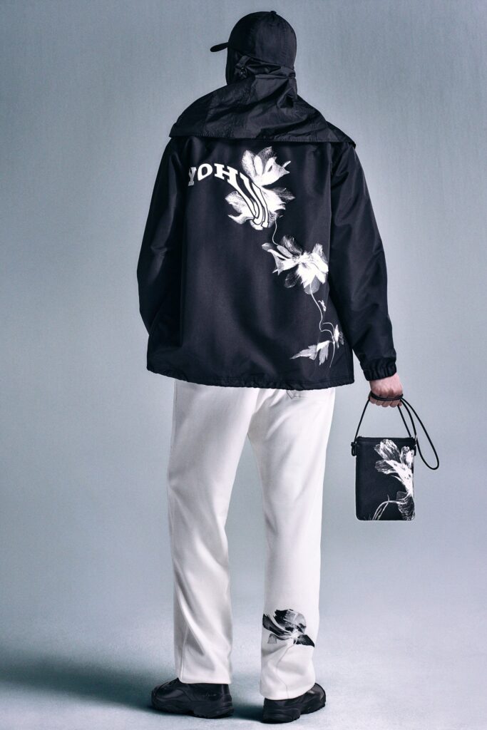 A relaxed black printed jacket paired with white pants, featuring floral designs.