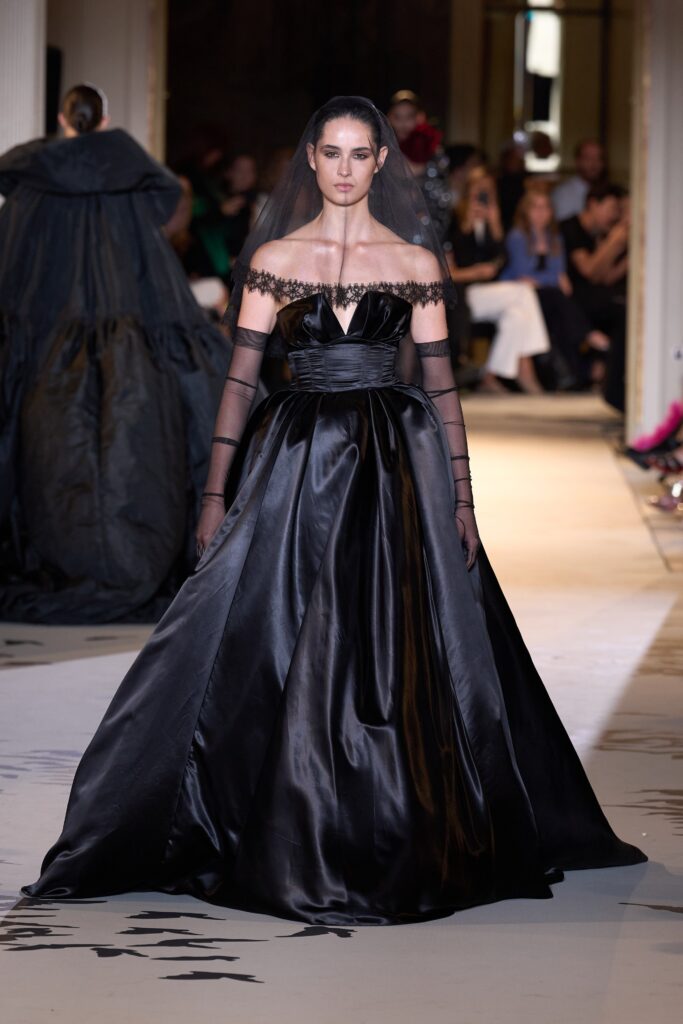 A fitted black silk strapless gown featuring a tiered design for a dramatic silhouette.