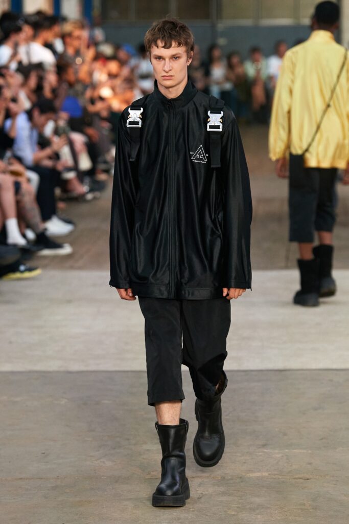 A relaxed black cotton jacket with long sleeves and zippered detail, paired with matching pants.