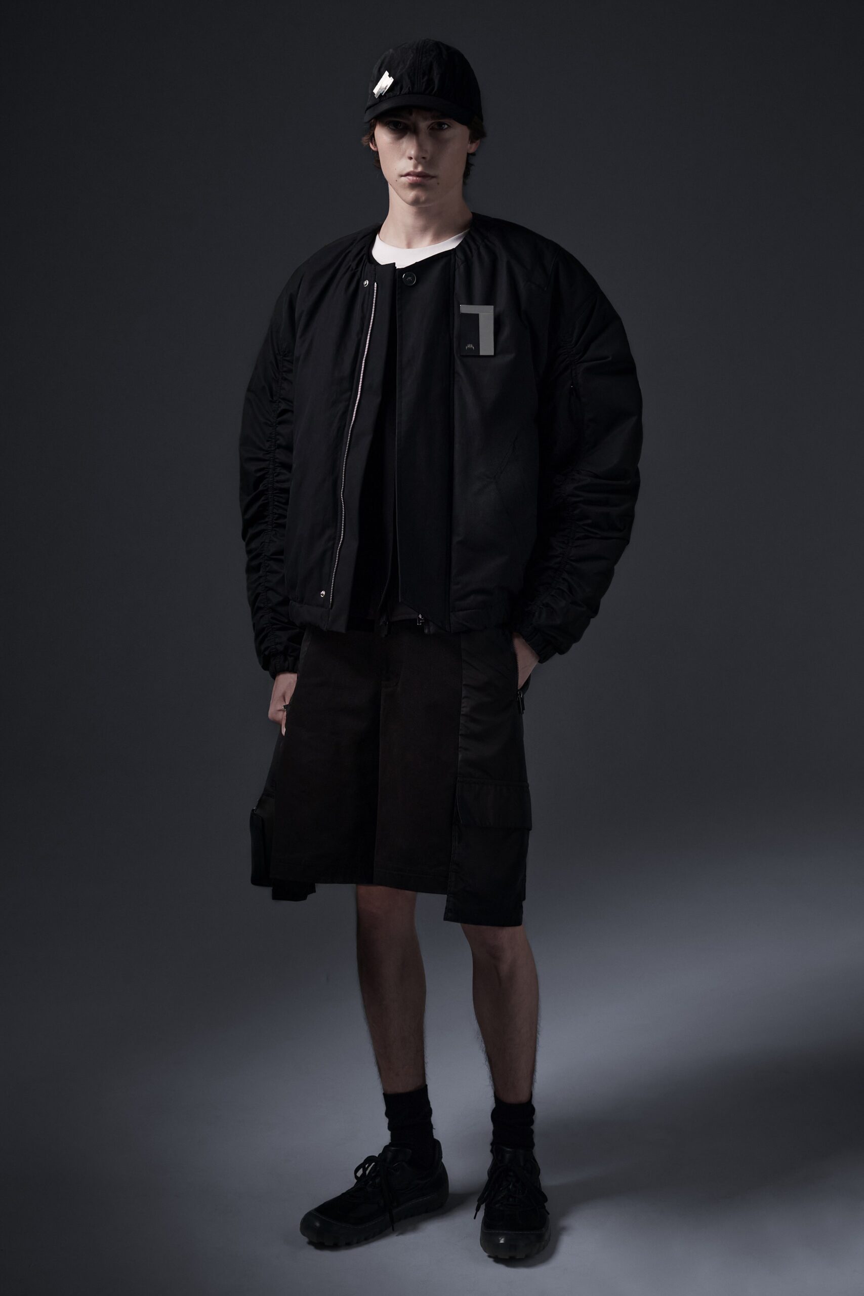 A relaxed black jacket with long sleeves and a collared design paired with matching shorts.