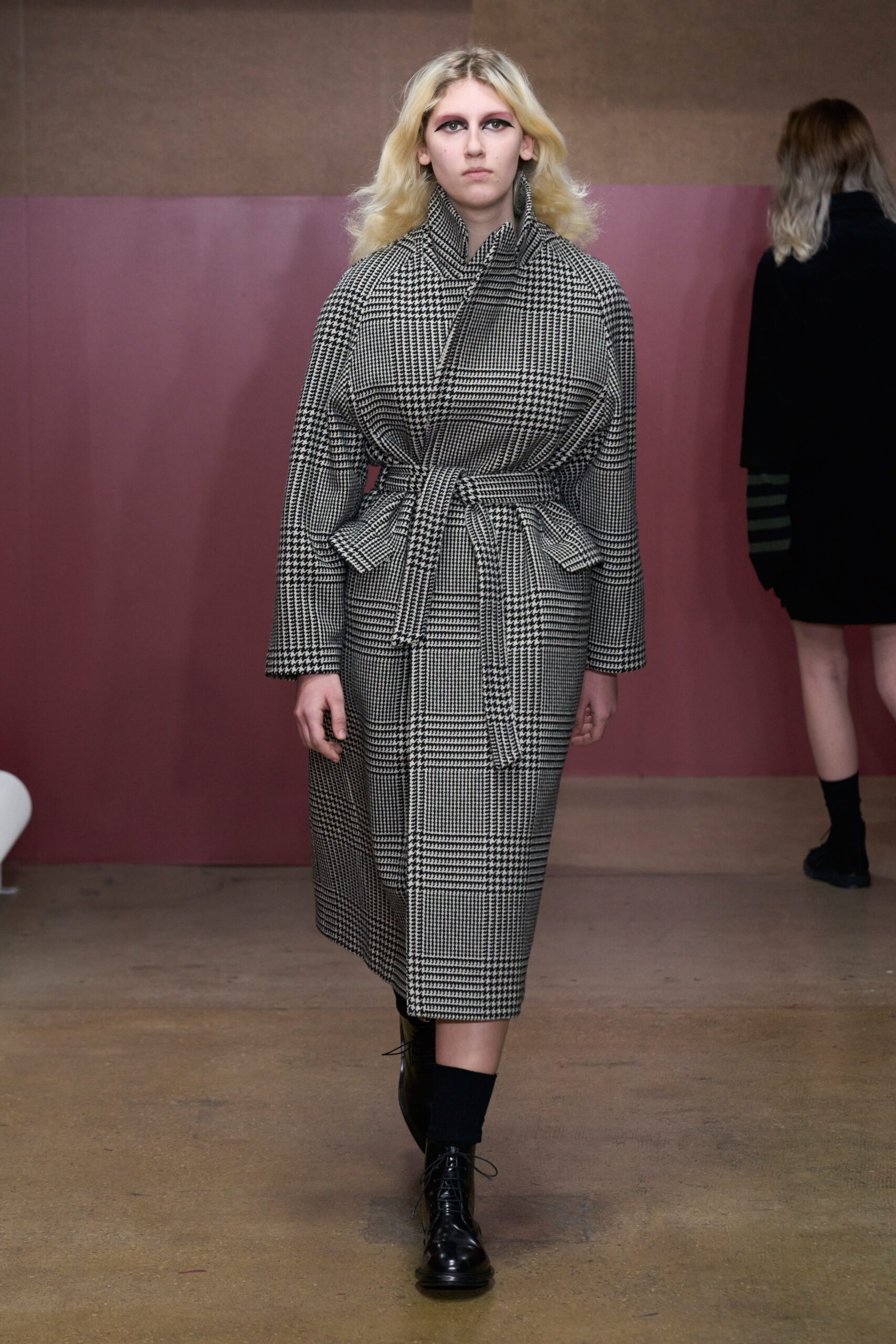 A relaxed black and white checked coat with long sleeves and a collared design.
