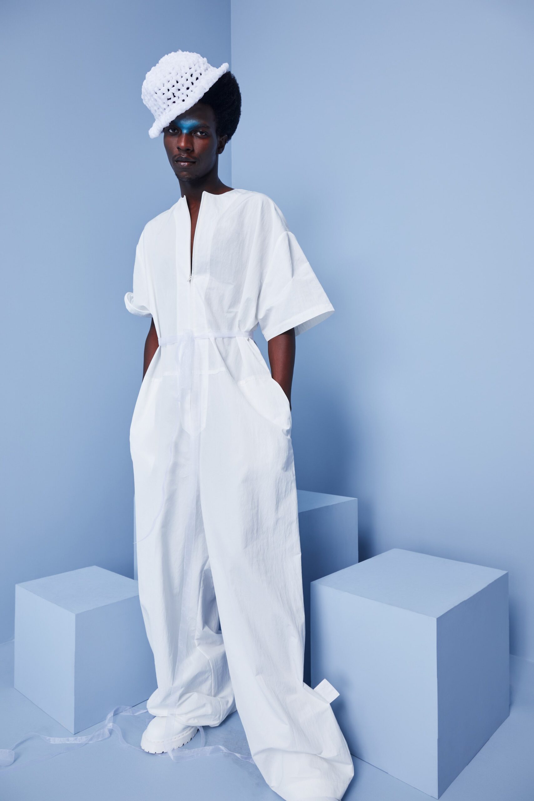 This relaxed jumpsuit in crisp white cotton features a collared neckline and short sleeves, offering a contemporary silhouette. The wide-leg design enhances movement and adds an airy quality, making it a versatile choice for various settings.