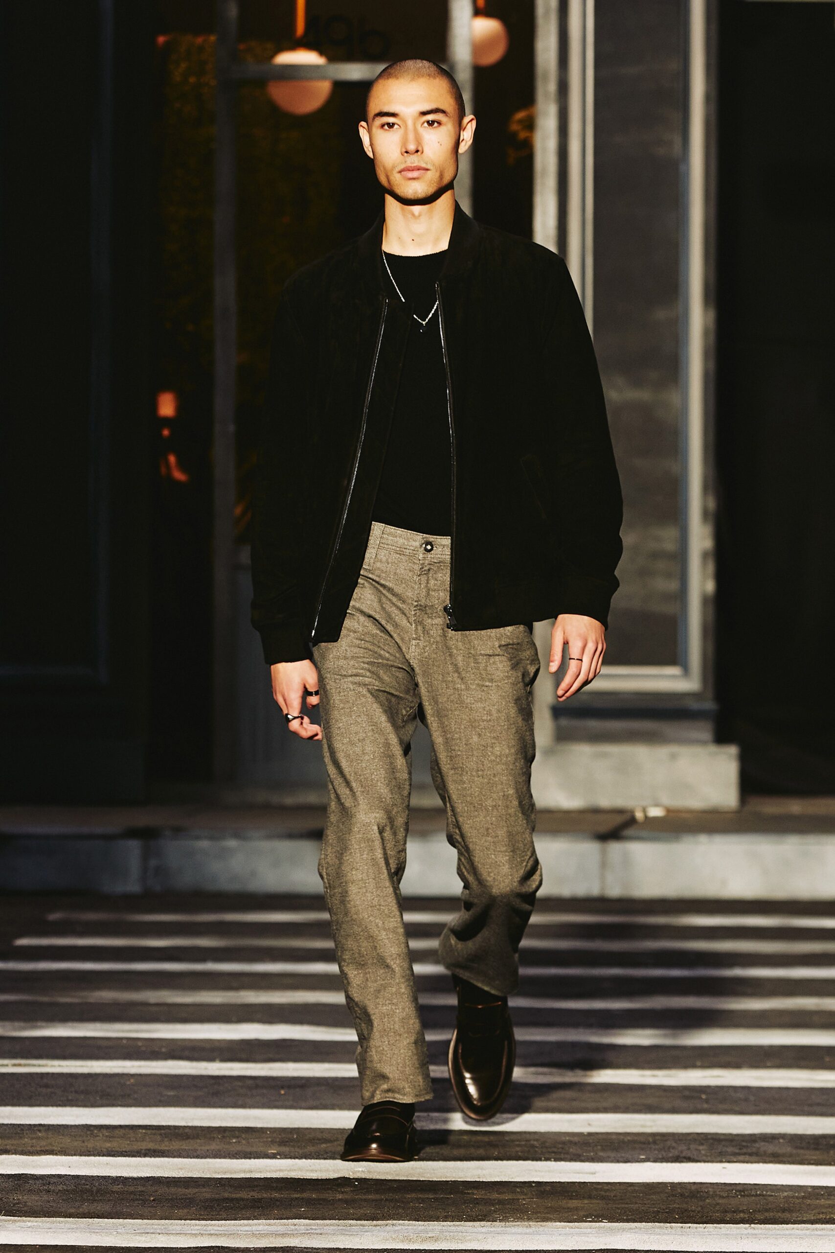 A fitted black jacket paired with gray straight-leg pants for a stylish look.