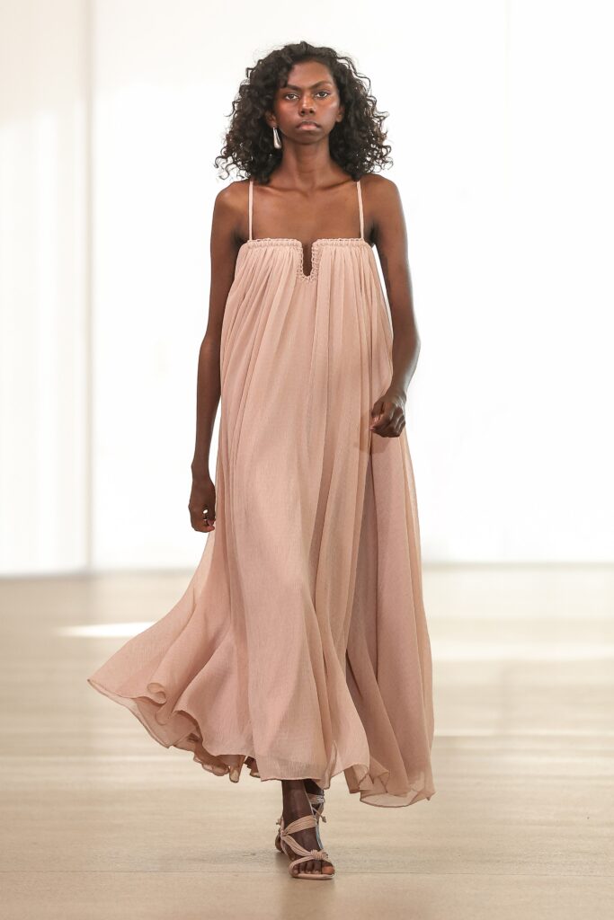 A relaxed beige silk sleeveless dress with a V-neckline and tiered design.