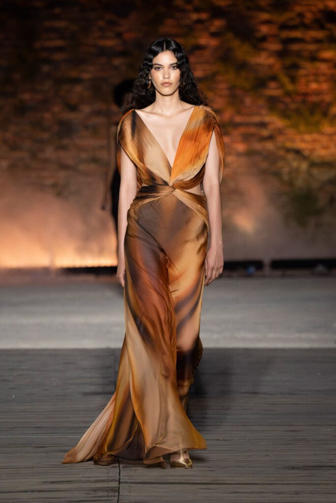 A fitted brown and beige silk gown with a sleeveless design and draped details.