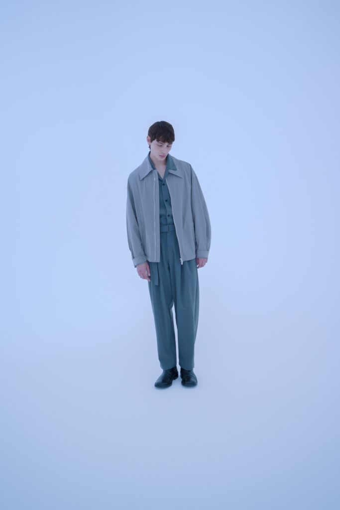 A relaxed gray jacket with long sleeves paired with straight-leg pants.