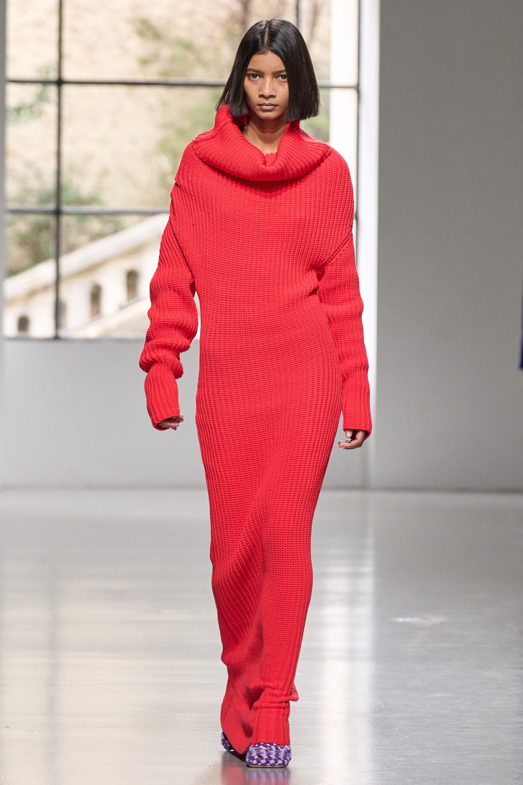 A fitted red knit dress with long sleeves and a high neckline, featuring a straight-leg silhouette.