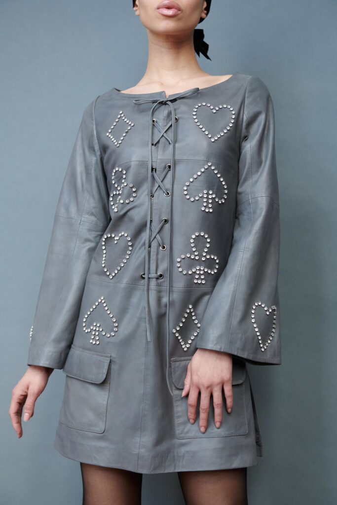 A fitted gray leather dress with long sleeves and embroidered details.