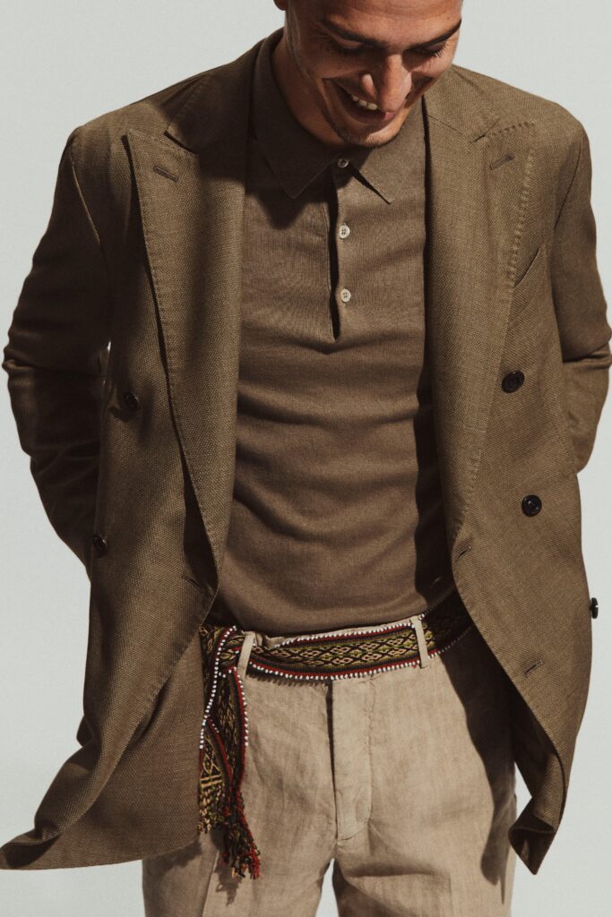 A fitted brown blazer paired with a collared long-sleeve shirt, featuring button detailing.