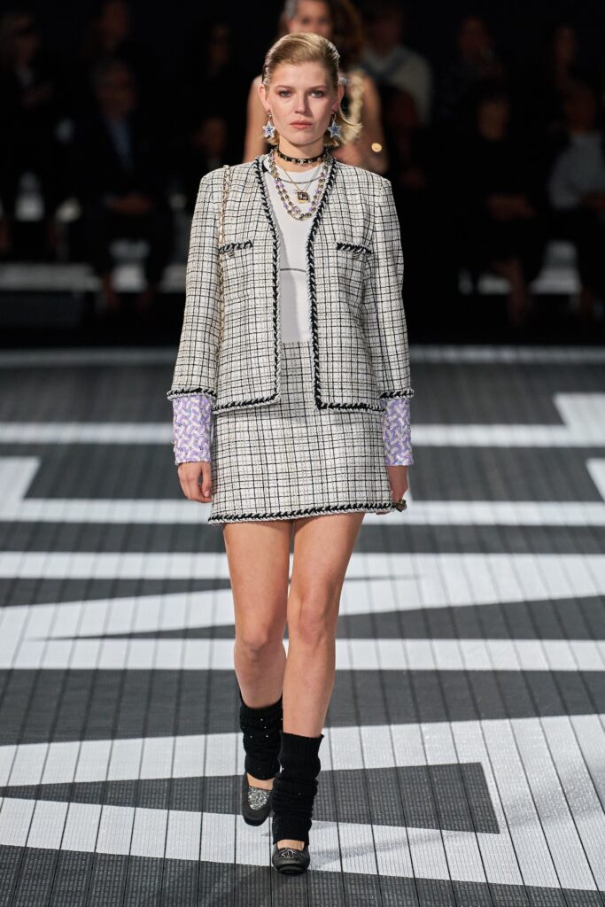 A fitted black and white checked tweed jacket paired with a matching skirt.