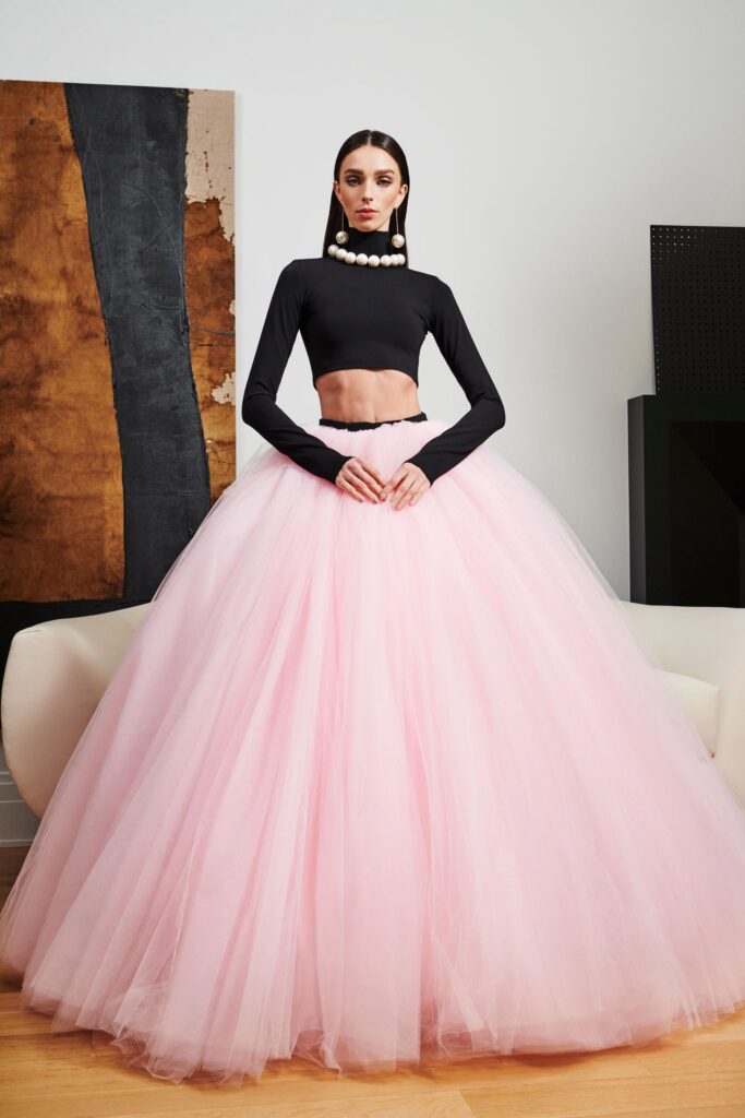 A fitted black long-sleeve cropped top paired with a tiered pink tulle skirt.