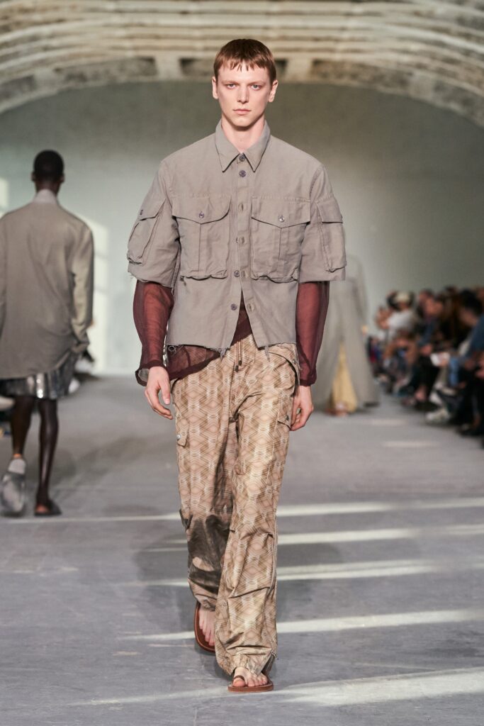 A relaxed gray collared shirt paired with printed wide-leg beige pants.