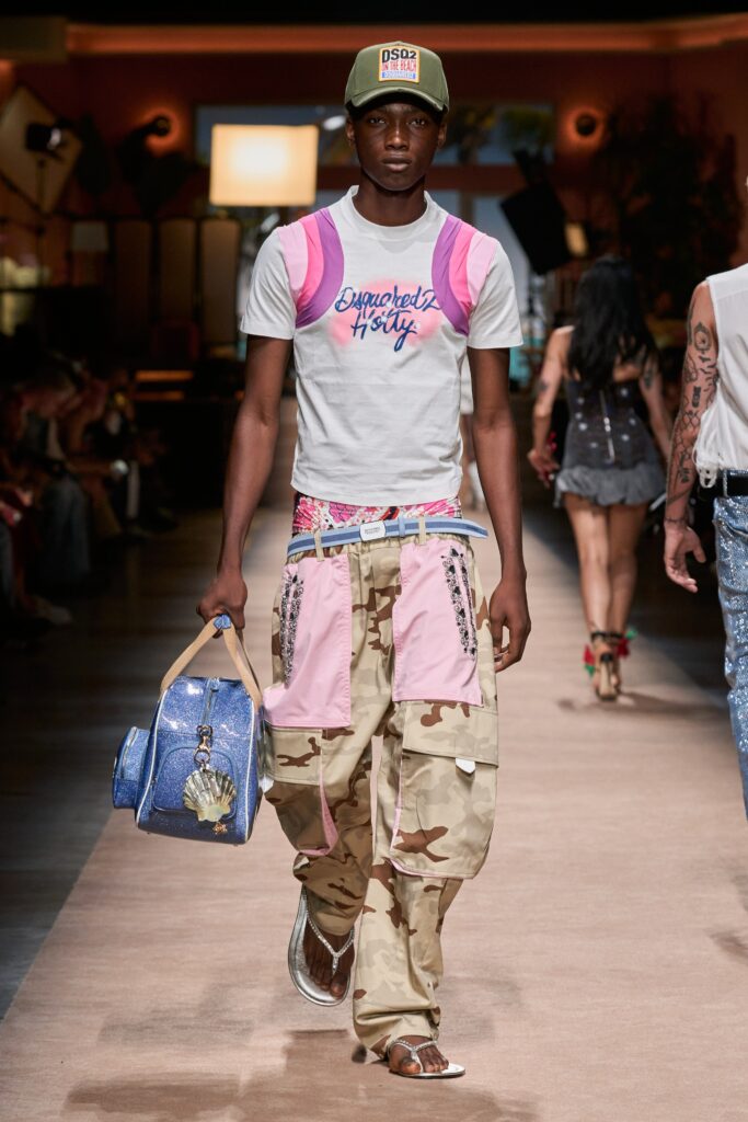 A relaxed white t-shirt with short sleeves paired with layered camouflage pants.
