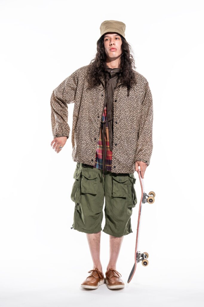 A relaxed brown printed jacket paired with green cargo shorts for a casual look.