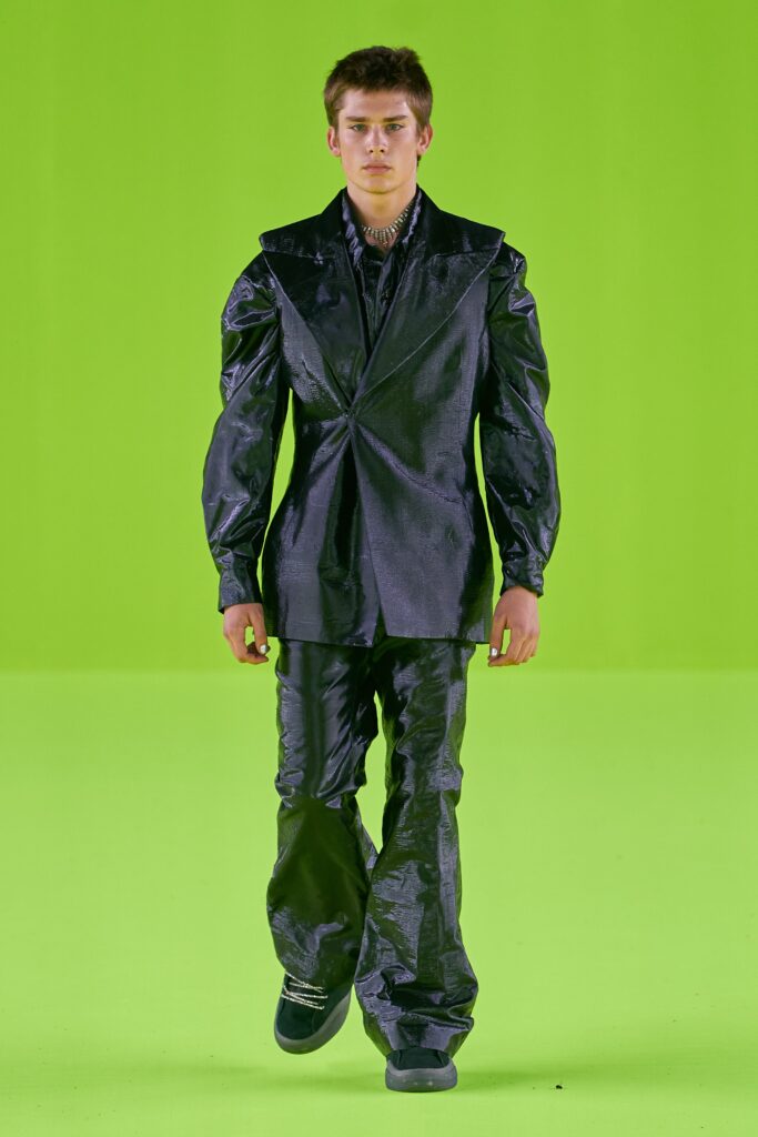 A fitted black silk suit with long sleeves and a structured design.