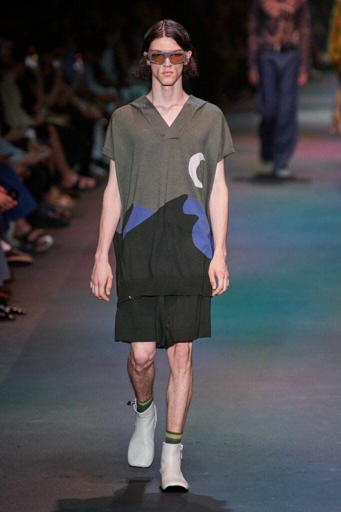 A relaxed green dress with a hood and short sleeves featuring a colorful print.