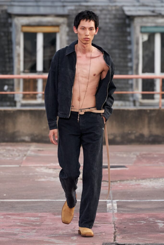 A fitted black denim jacket with long sleeves and collared design paired with straight-leg pants.