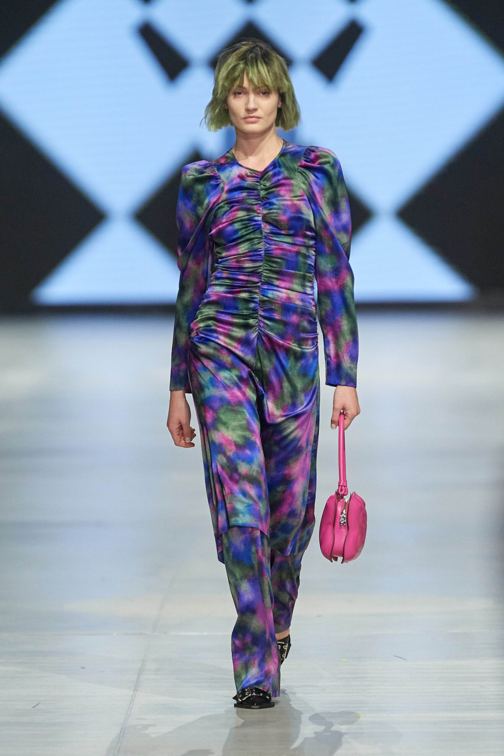 A fitted multicolor silk jumpsuit with long sleeves and a V-neckline featuring ruched detailing.