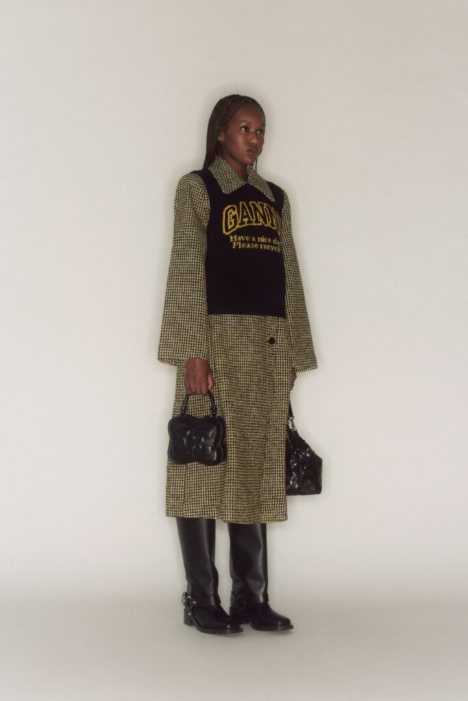 A relaxed fit checked coat layered over a black top with long sleeves and a collared design.