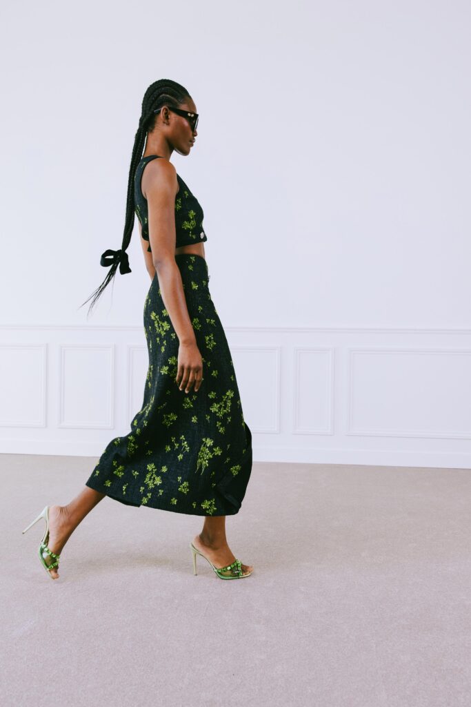 A fitted black sleeveless top paired with a tiered floral skirt, creating a stylish ensemble.