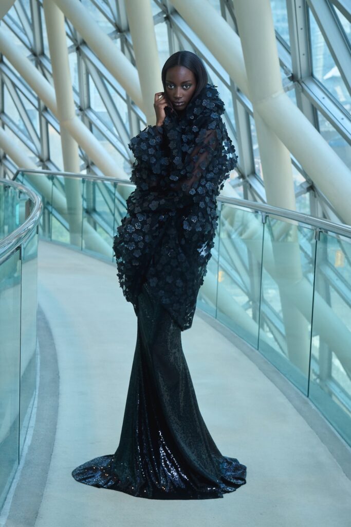 A fitted black silk long-sleeve dress with a V-neckline and layered design details.