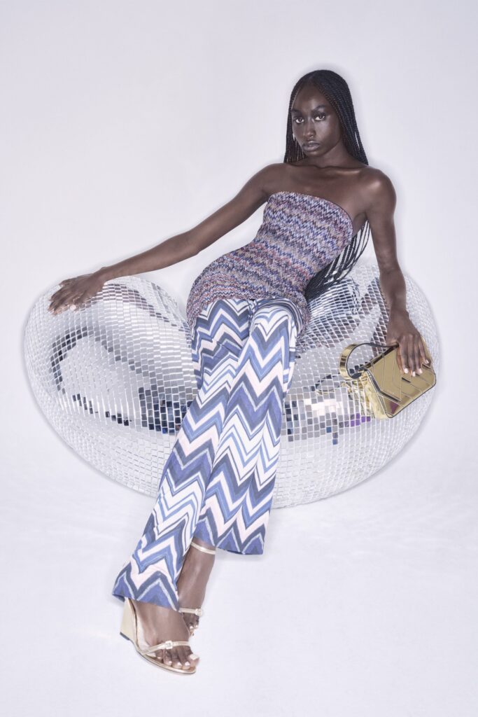 A fitted strapless jumpsuit in blue and white with a vibrant printed design.