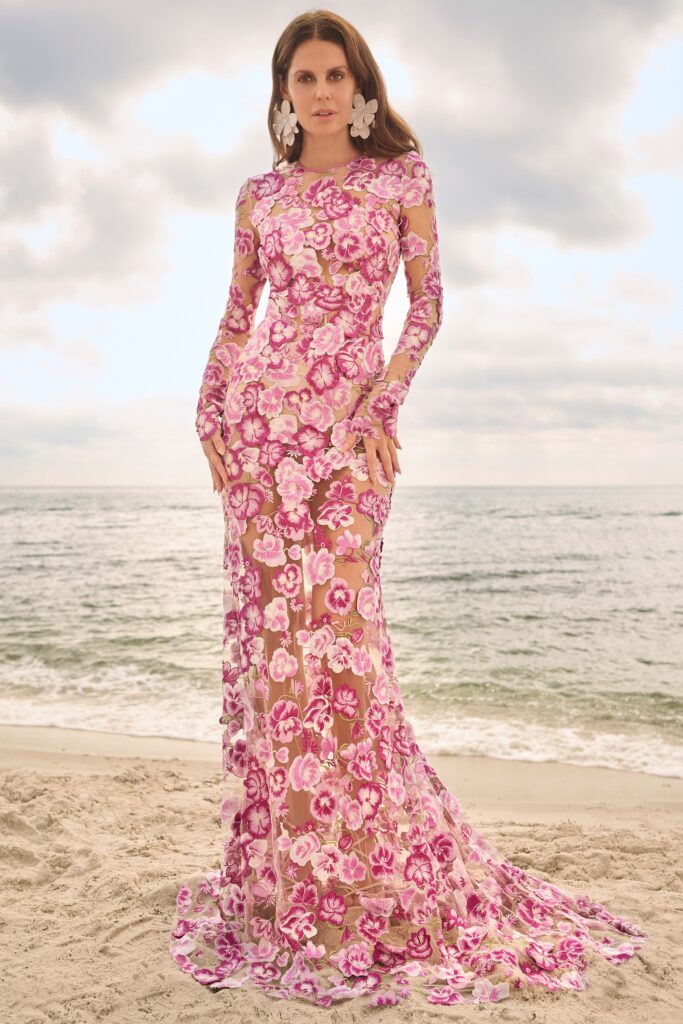 A fitted pink lace gown with long sleeves and a high neckline, featuring a flared silhouette.