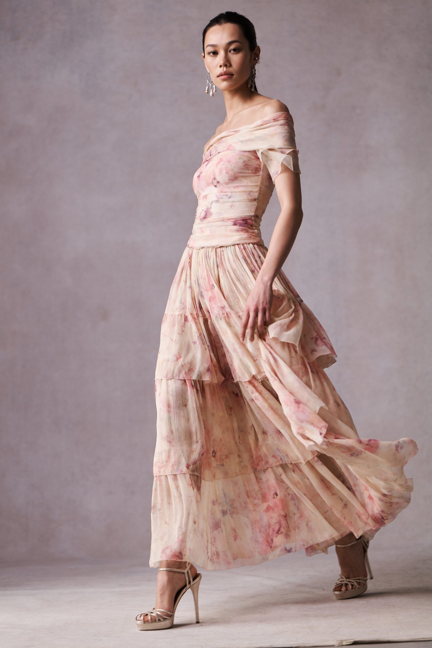 A relaxed beige and pink silk off-shoulder dress with a tiered design.