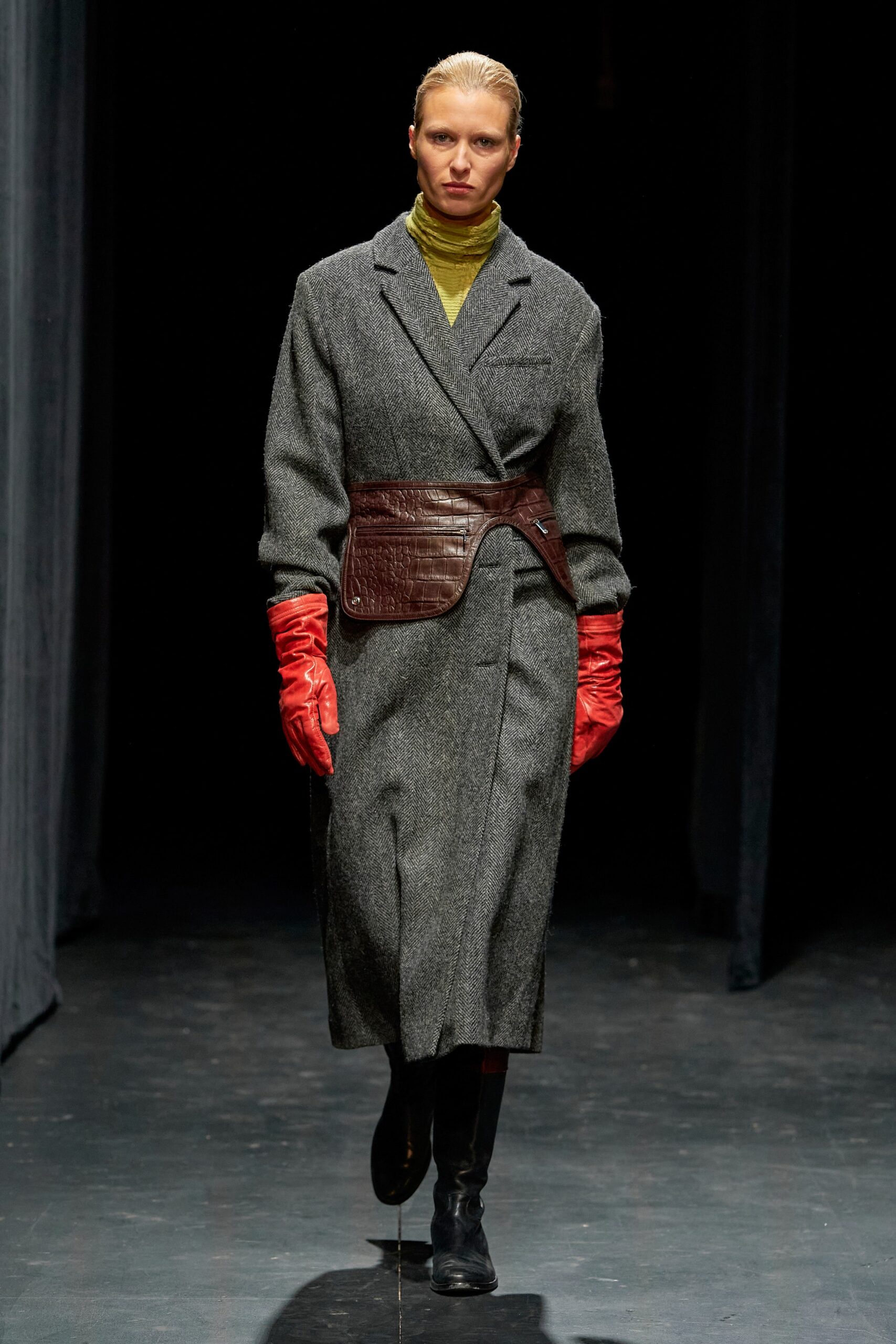 A relaxed gray wool coat with long sleeves, a collared neckline, and a belted detail.