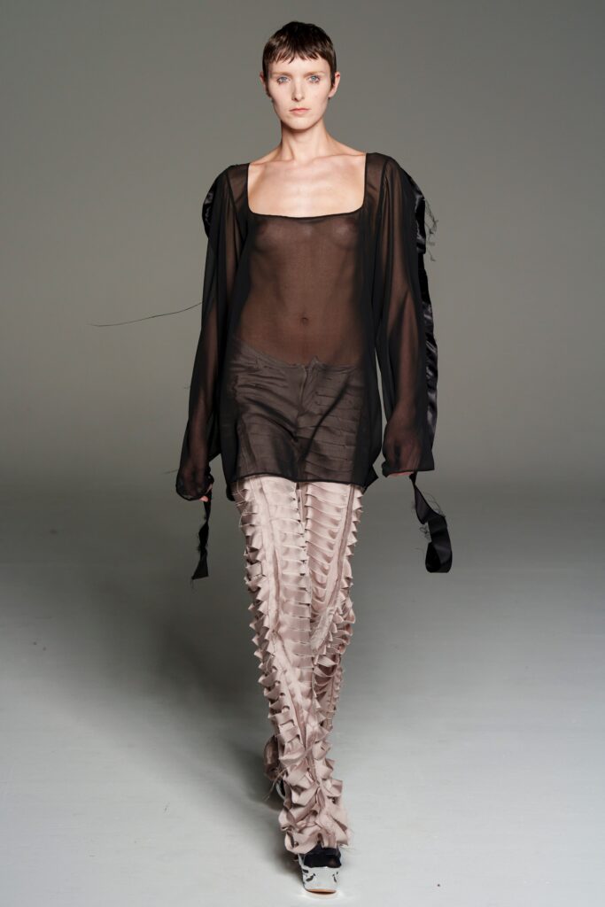 black sheer top with beige pants