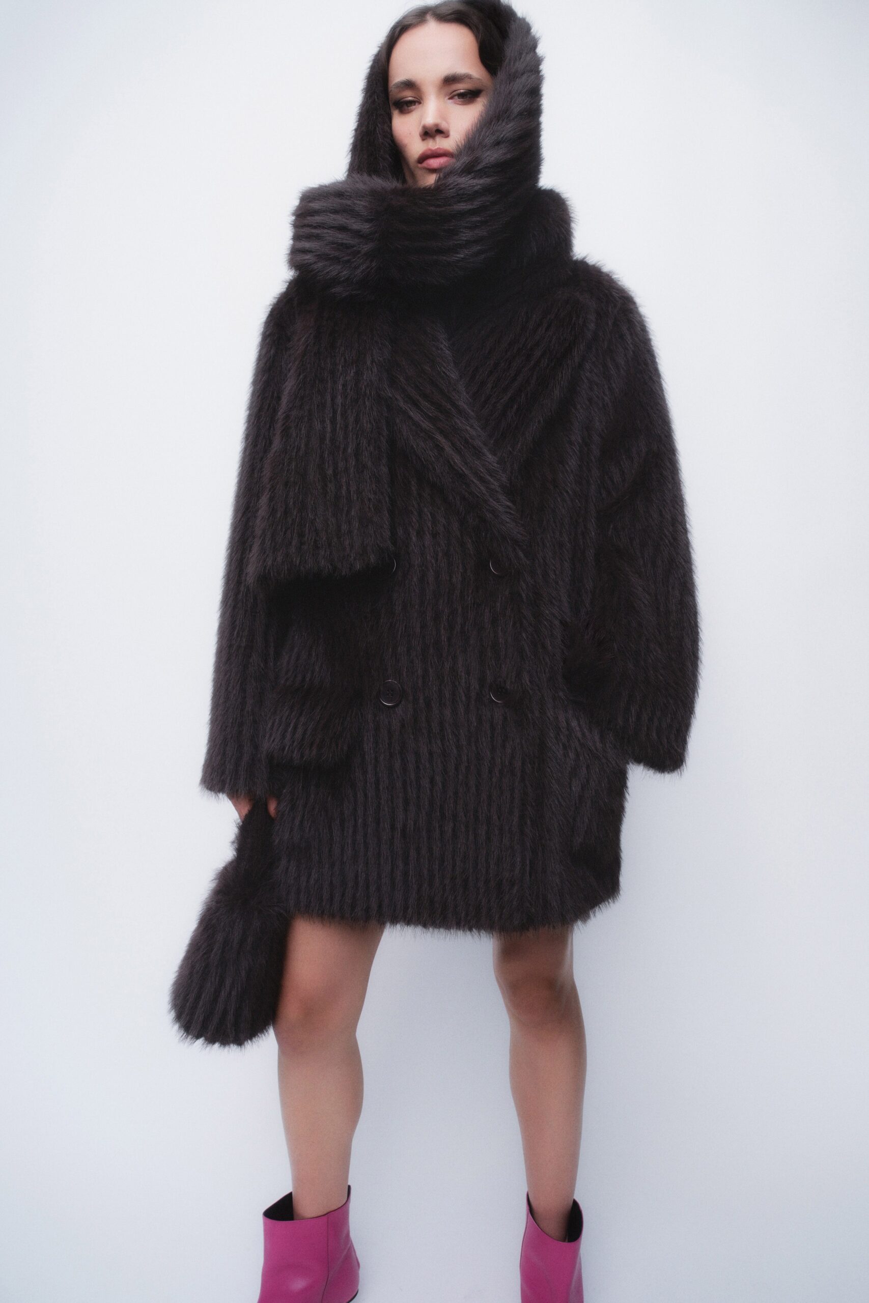 An oversized black wool coat with long sleeves and a collared design, featuring button details.