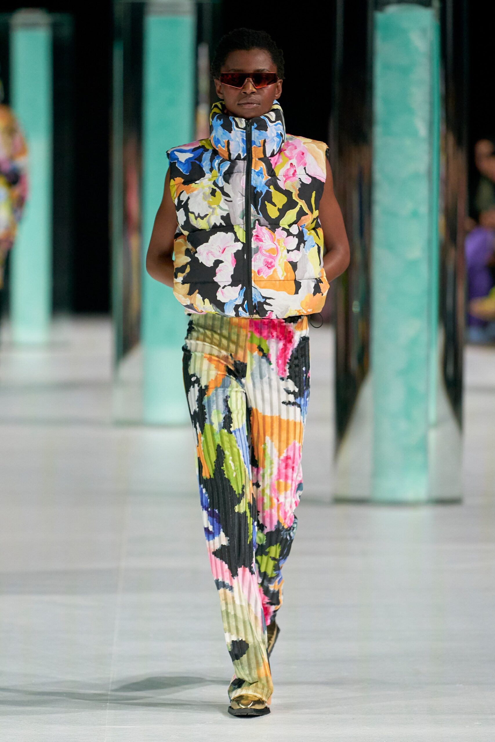 A relaxed multicolor sleeveless top with a collared design paired with pleated pants.