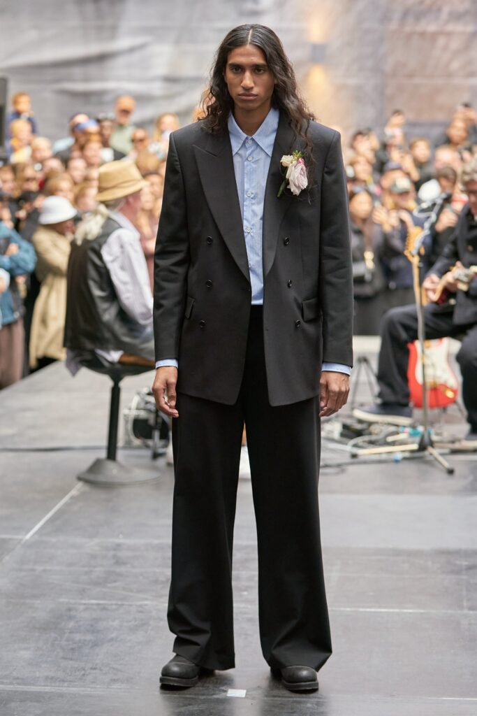 A relaxed black wool suit with long sleeves and a double-breasted design.