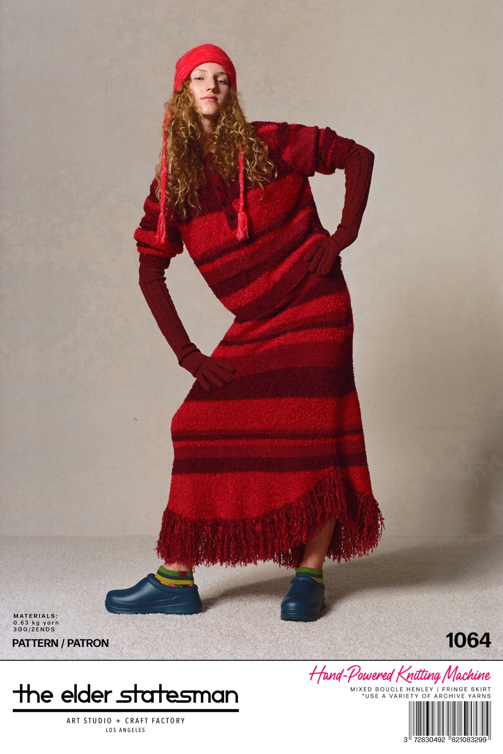 A relaxed red cotton dress with long sleeves, a hood, and fringed detailing.