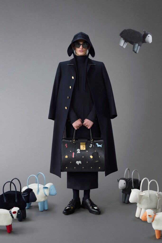 An oversized black wool coat with long sleeves and a collared design, featuring button details.