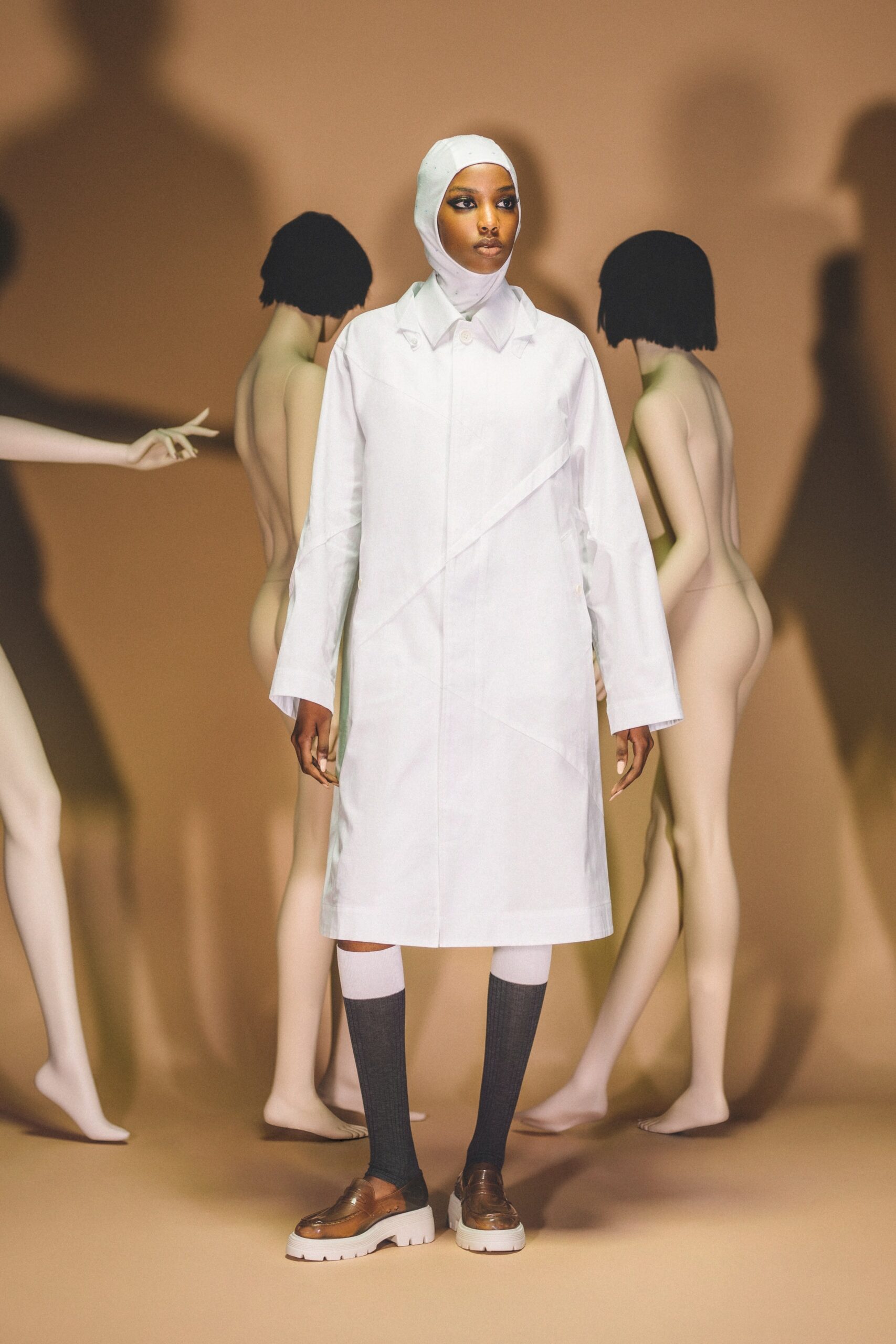 A relaxed white cotton coat with long sleeves and an asymmetric design.