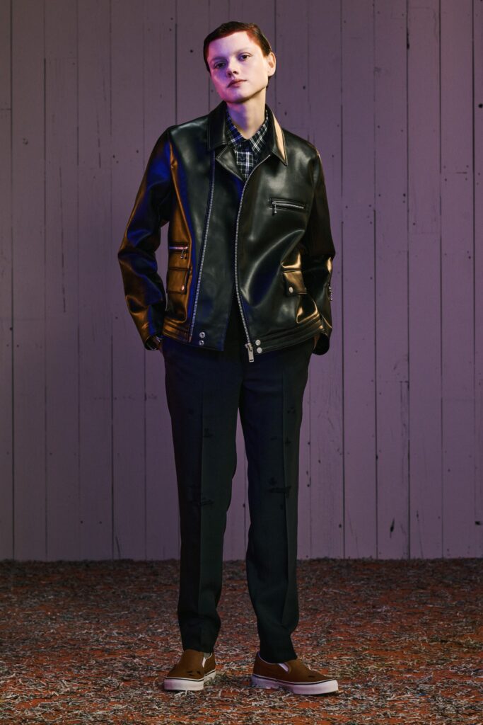 A fitted black leather jacket with a collared neckline paired with sleek black pants.