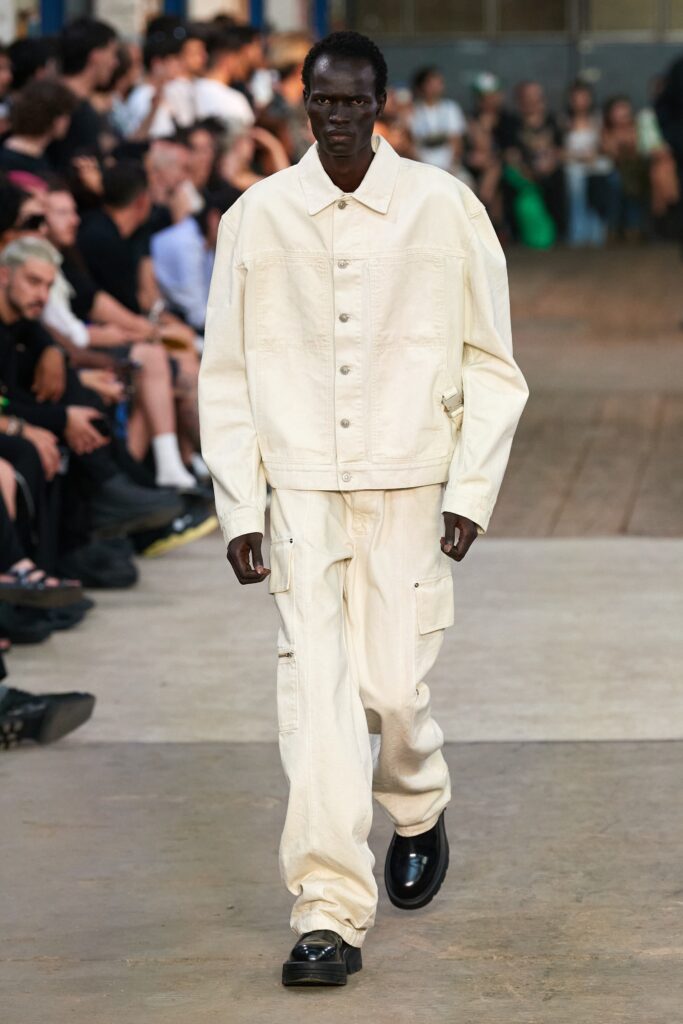 An oversized white denim jacket paired with matching pants, featuring a collared design and buttoned details.