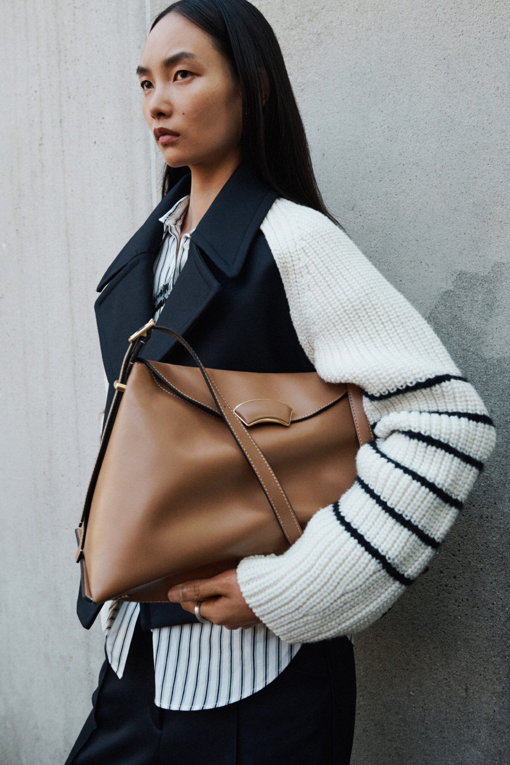 A fitted black and white striped long-sleeve shirt paired with a stylish jacket.