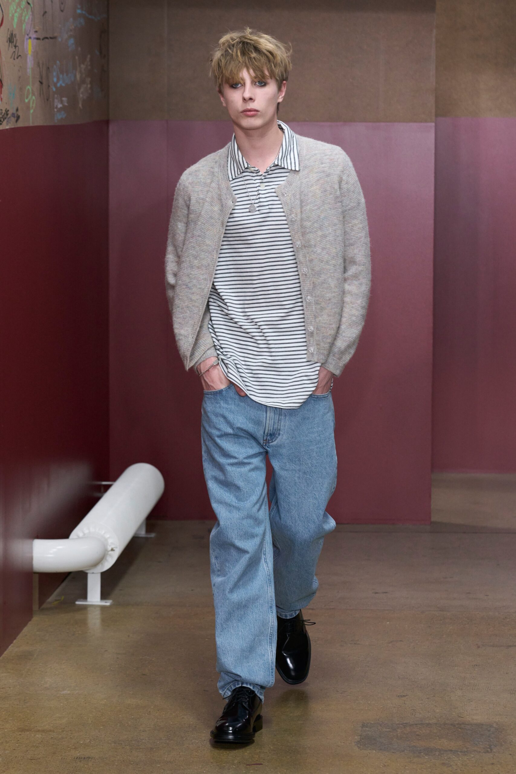 A relaxed gray wool cardigan layered over a collared striped shirt.