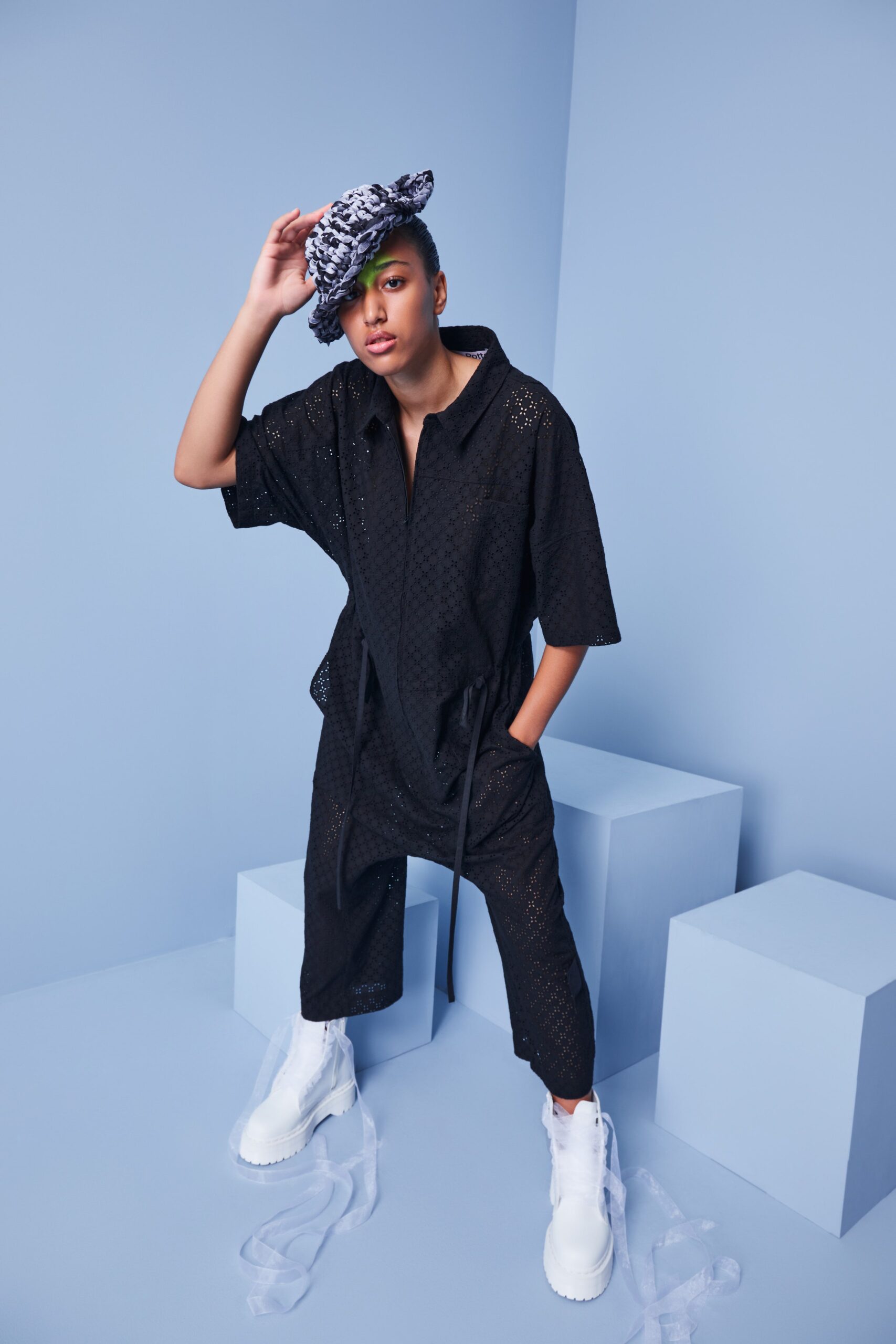 This relaxed jumpsuit in black cotton features short sleeves and a collared neckline, creating a laid-back yet structured silhouette. The layered design adds depth and visual interest, making it a versatile piece for various occasions.