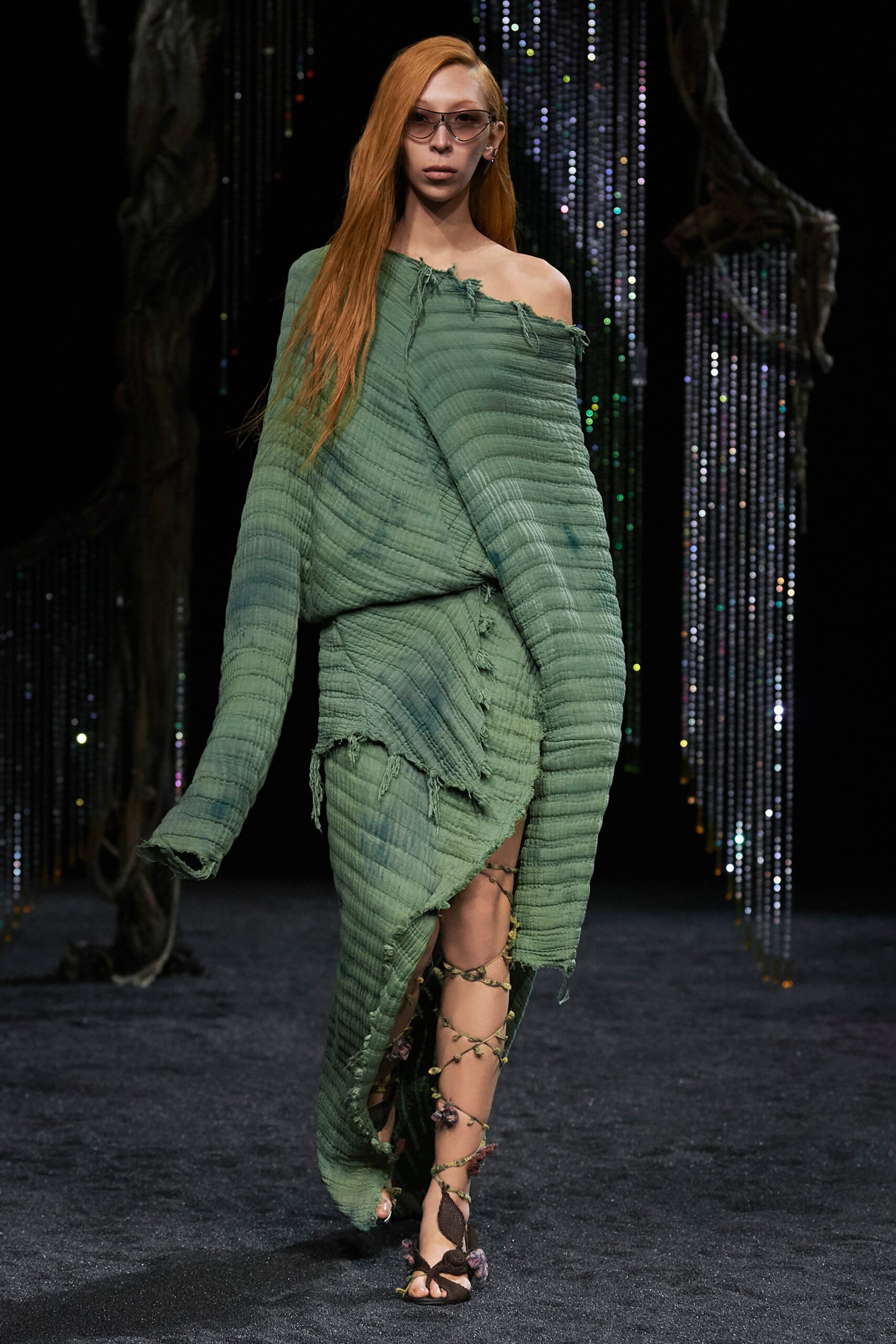 A relaxed green off-shoulder dress with an asymmetric and layered design.
