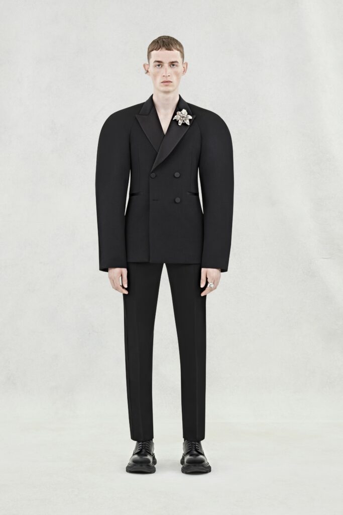 A structured black wool suit with long sleeves and a double-breasted design.