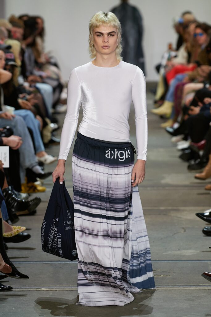 A fitted white long-sleeve top paired with a striped skirt in shades of blue.