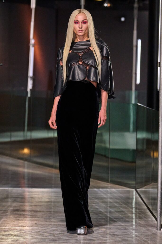 A fitted black velvet dress with a high neckline and straight-leg silhouette.