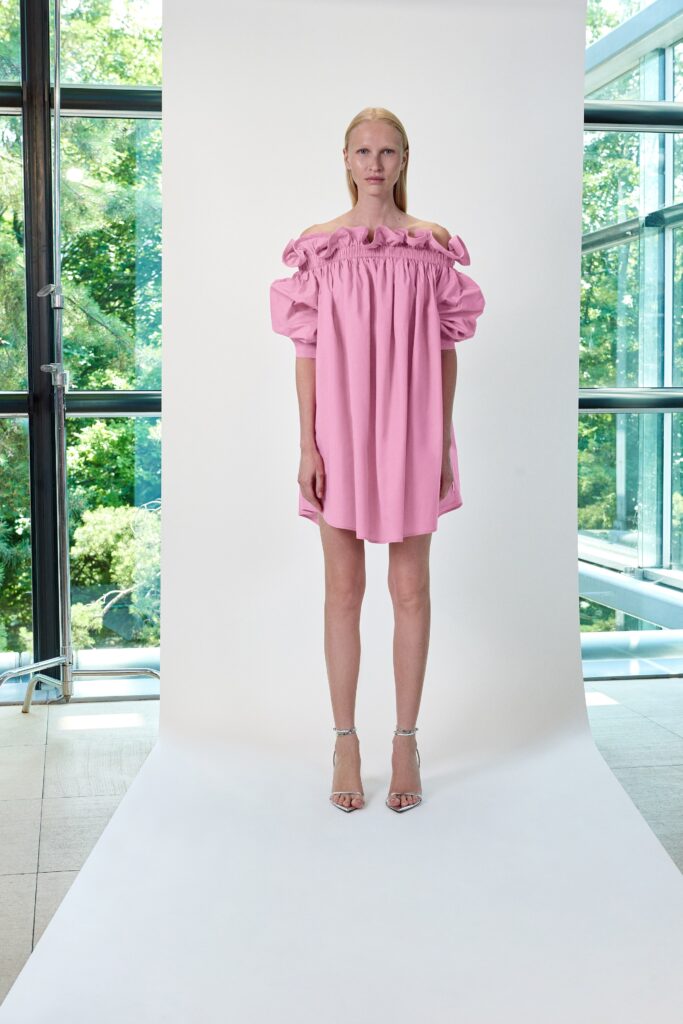 A relaxed pink off-shoulder dress with ruffled detailing for a playful look.