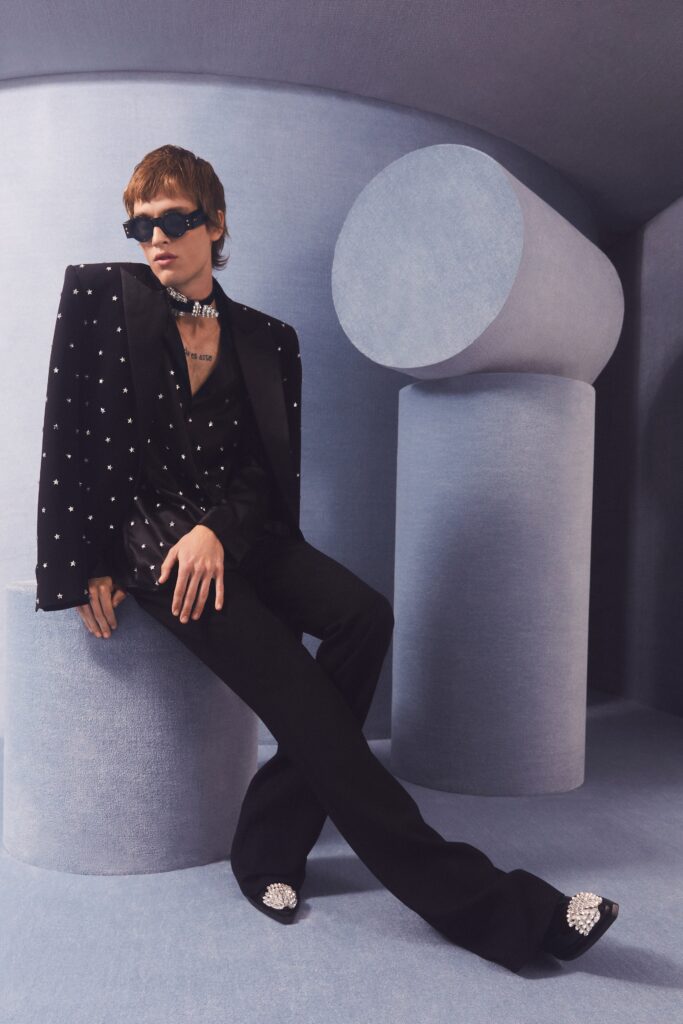 A tailored black silk blazer with matching pants, featuring long sleeves and a chic design.