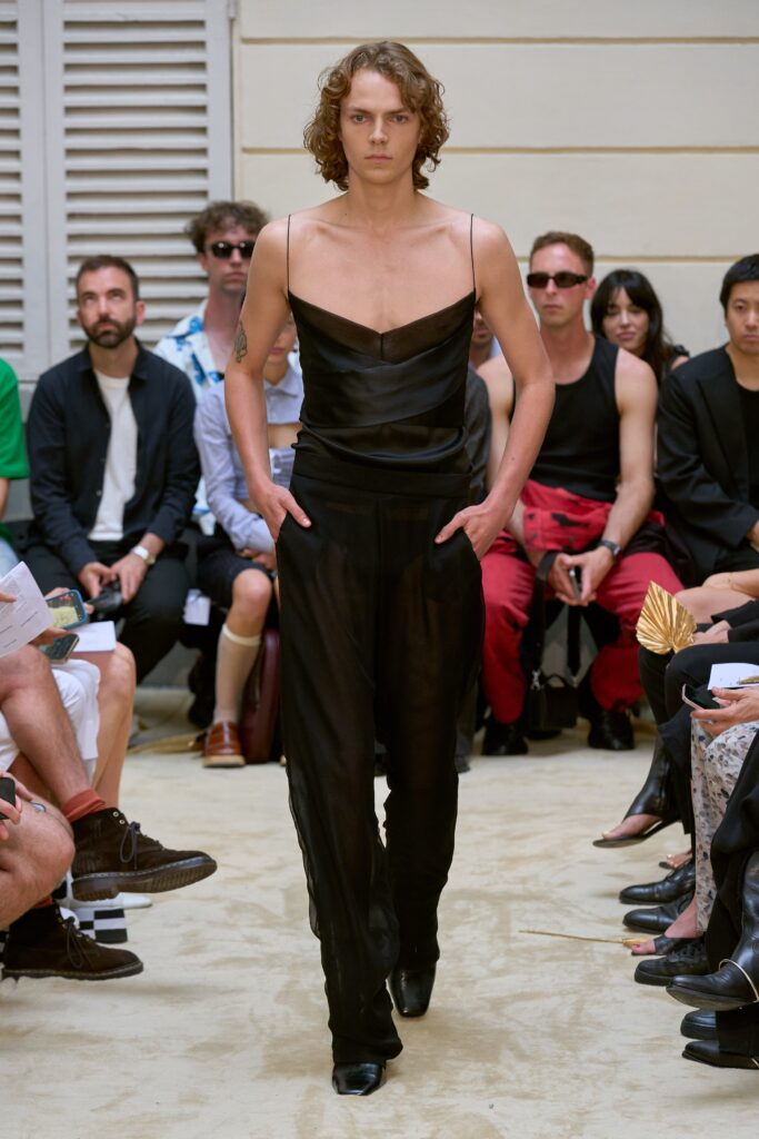 A fitted black silk sleeveless jumpsuit with a V-neckline and straight-leg design.