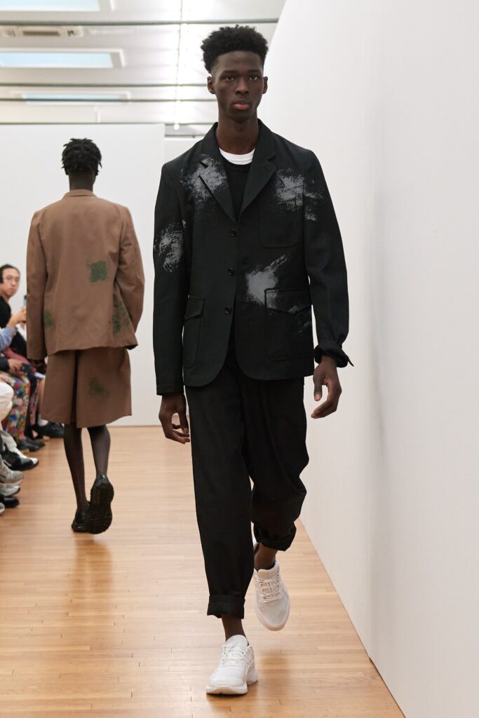 A relaxed black jacket with a collared neckline and printed details paired with matching pants.